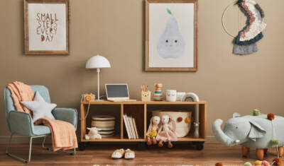 Stylish scandinavian kid room interior with toys, teddy bear, plush animal toys, mint armchair, furniture, decoration and child accessories. Brown wooden mock up poster frames on the wall. Template